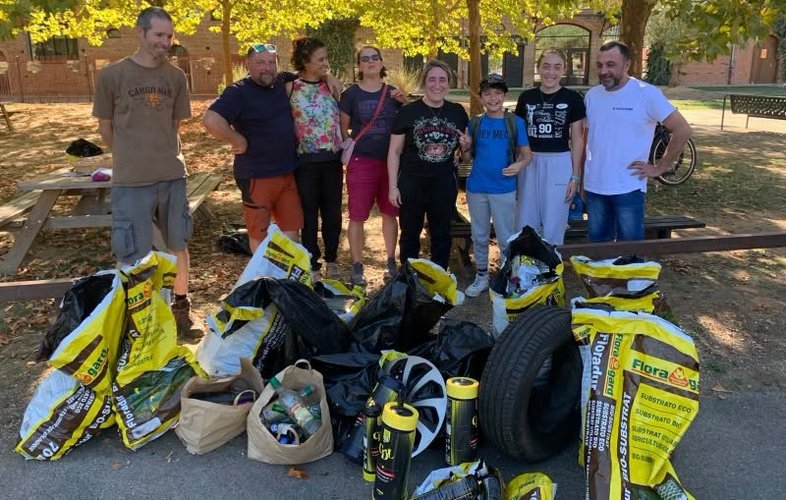 groupe de bénévoles devant les sacs de déchets ramassés